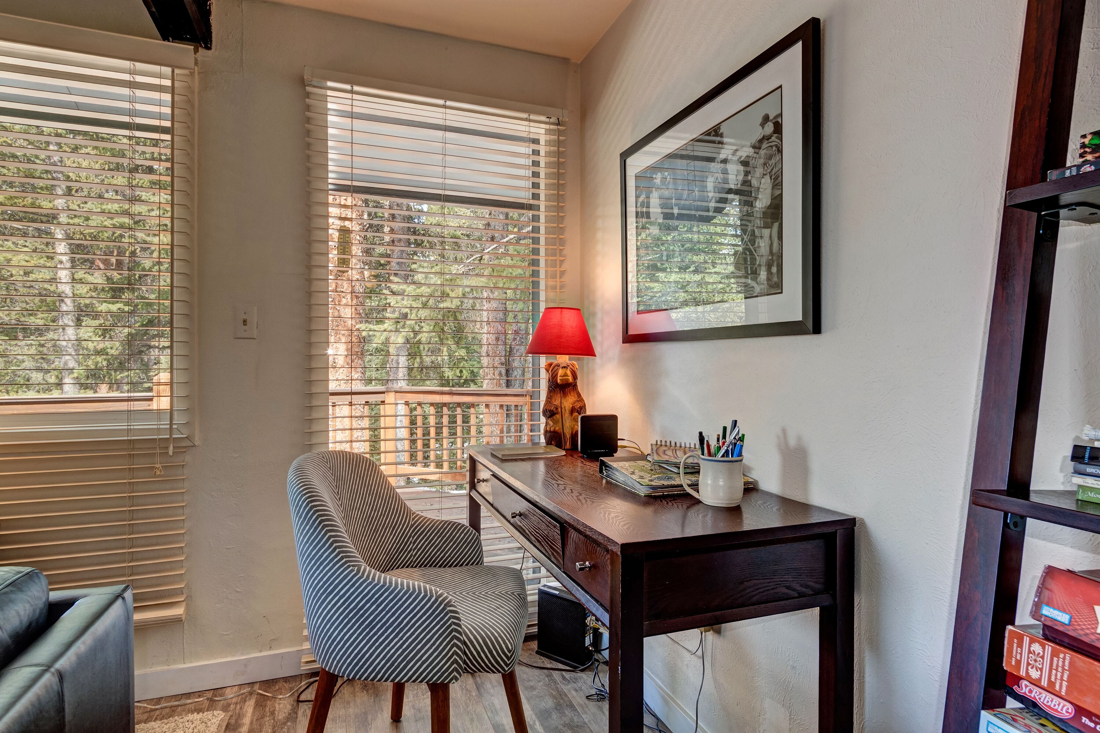 A room with a desk, chair, and a window with blinds.