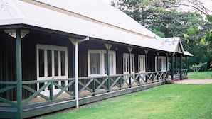 A long, single-story building with a covered porch and a green railing.