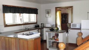 A compact kitchen with a central island, a microwave, and a refrigerator.