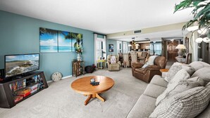 Un salon spacieux avec un téléviseur, une table basse et un canapé.
