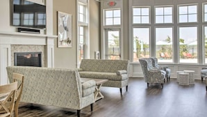 Eine geräumige Lobby mit Kamin, gemusterten Sofas und großen Fenstern mit Blick ins Freie.