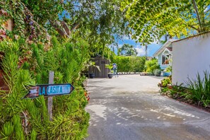 A street sign labeled 'LA CASITA' with a paved road, greenery, and a building in the background. - Relaxing, Romantic, and Fun! Private, Quiet, and Less than a mile to the Ocean! (Oceanside)