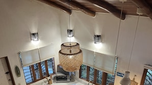 Een moderne keuken met witte kasten, een houten kookeiland met barstoelen, een inbouwoven en een groot raam met uitzicht.