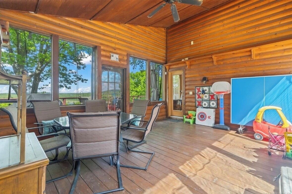 A wooden deck with outdoor seating and a basketball hoop.