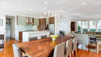 A modern kitchen with wooden cabinets, a central island, and pendant lighting.