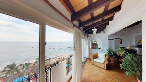 A balcony with a view of the sea, a wicker sofa, and potted plants. - Great Penthouse at El Dorado 3BD Penthouse for rent in Los Muertos Beach, Puerto (Puerto Vallarta)
