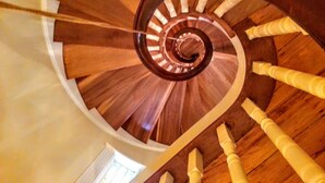 Un escalier en colimaçon avec des marches en bois et une rampe centrale.