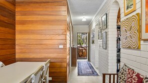 A hallway with wooden paneling, a white door, and a patterned rug. - Anjuna, 2 bedroom apartment on canal (Mooloolaba)