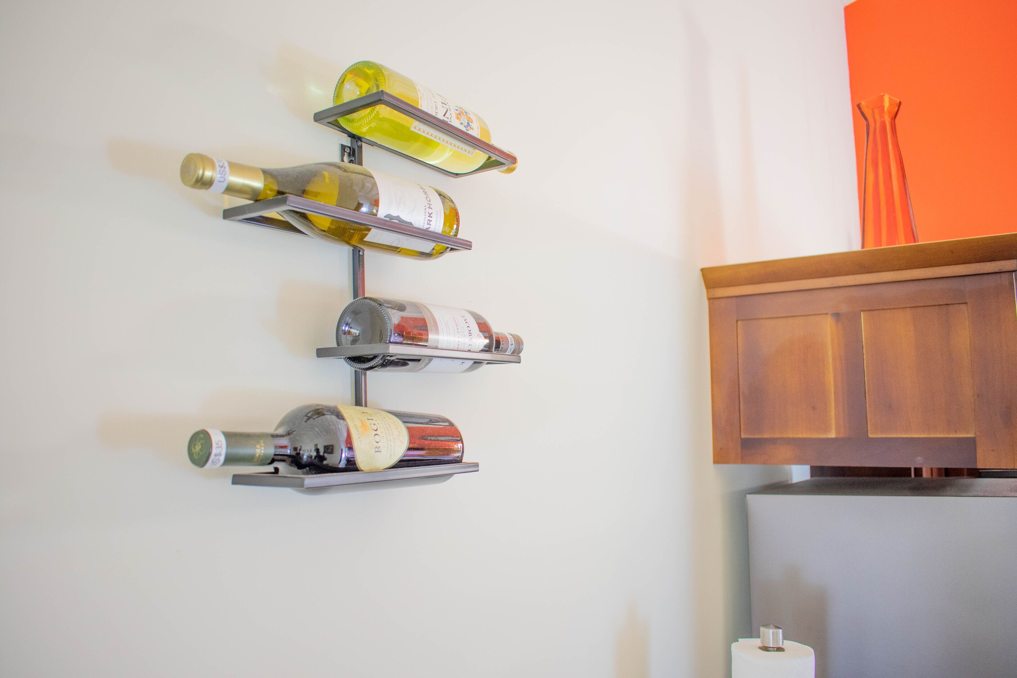 Un porte-bouteilles à vin fixé au mur, contenant plusieurs bouteilles.