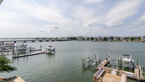 Un port de plaisance avec des quais et des bateaux, un pont en arrière-plan et des immeubles résidentiels le long de la rive.