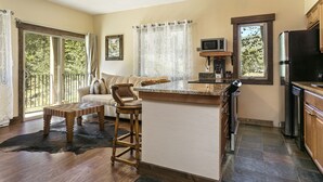 A modern kitchen with a large island, bar stools, a microwave, and a refrigerator. - Entire 1BR apt, Sleeps 4, Wi-Fi, Close to Slopes (Vail)