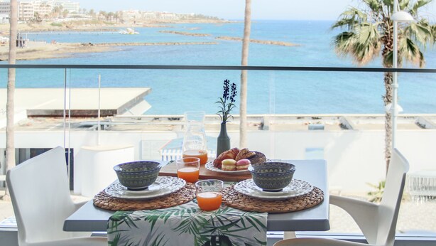A table with breakfast items and a view of the sea. - Phaedrus Living: Seaside Luxury Flat Lighthouse 53 (Paphos)