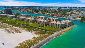 A coastal resort with multiple buildings, a beach, and a marina. - Land`s End Beachfront Elegance: Top Floor Corner (Treasure Island)