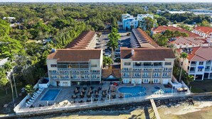 A hotel with multiple balconies, a swimming pool, and a beach area. - Waterfront Studio at Beso del Sol | Pool, Balcony, Sunset Bar (Dunedin)