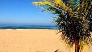 Een strand met heldere luchten en rustig water.