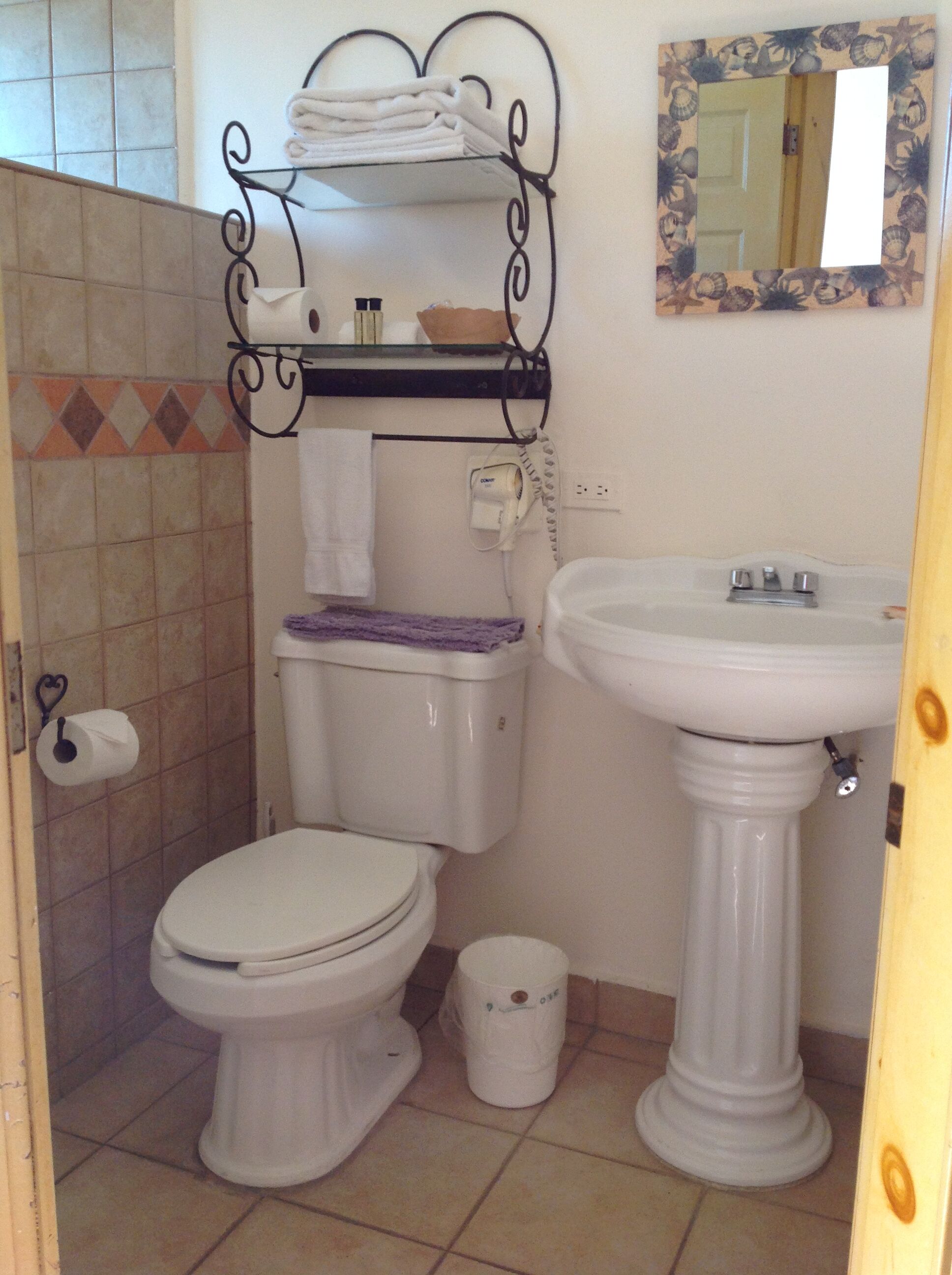 Une salle de bain équipée de toilettes, d’un lavabo et d’un porte-serviettes.