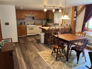 Une cuisine moderne avec des meubles de rangement en bois, une table à manger et des chaises.