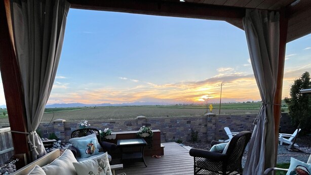 A covered outdoor seating area with a view of the sunset over a field. - Launchpad~3 Beds,  Rain Shower, Top Golf NearBy (Thornton)