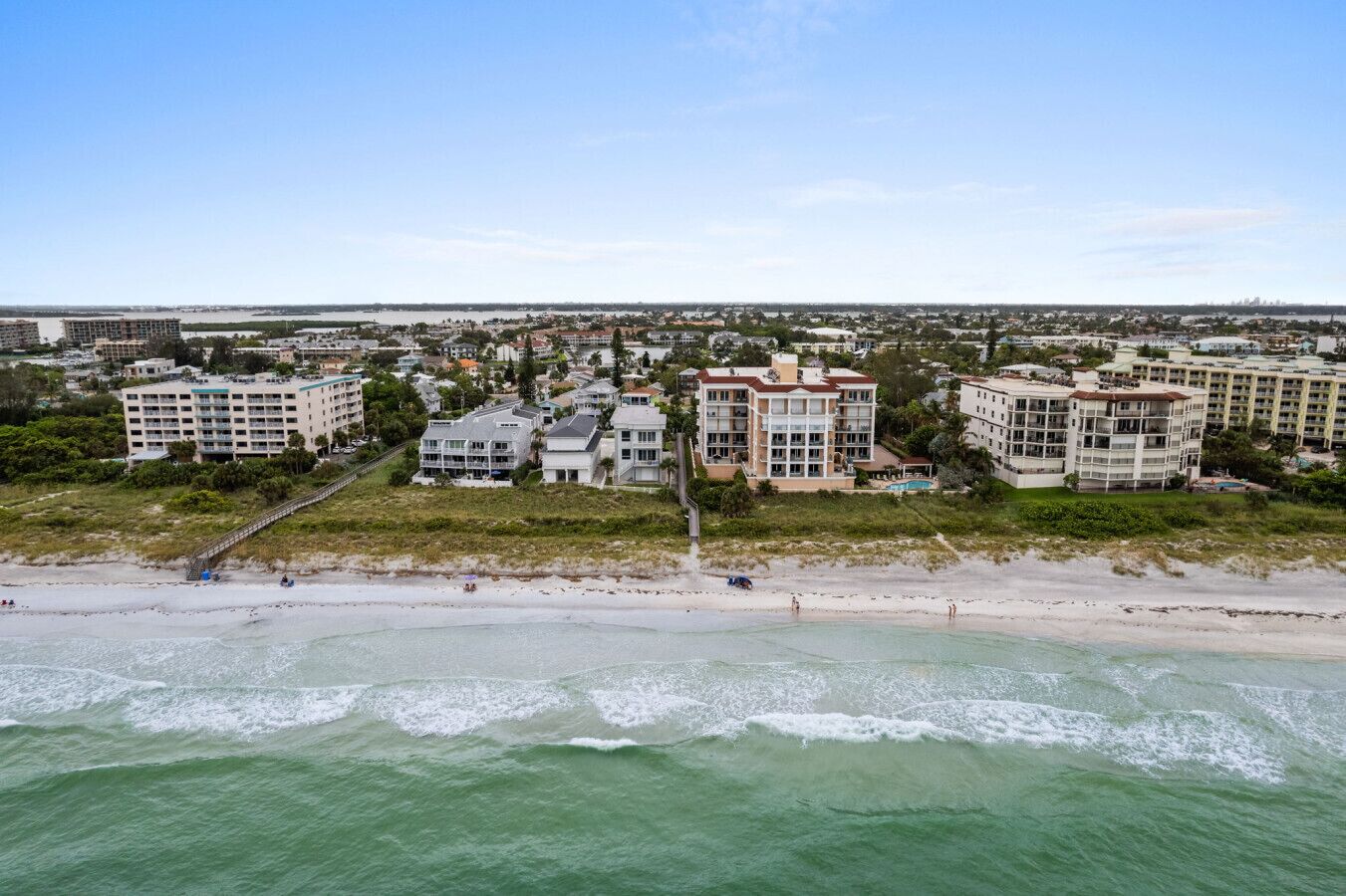 A coastal hotel with multiple buildings, a beach, and ocean views.
