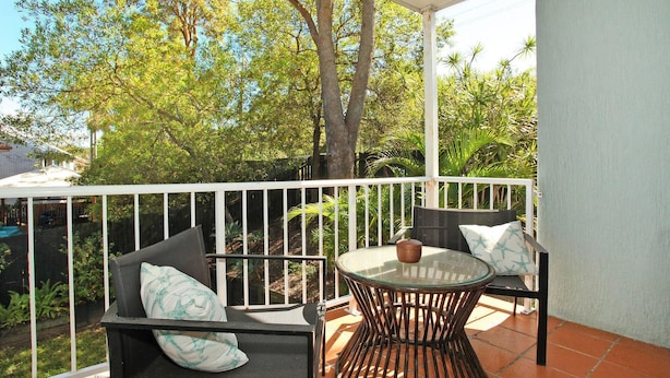 A patio with a glass table and two chairs, surrounded by a white railing. - Toorumbee 4/38 - Three Bedroom Townhouse Pet Friendly on Request* (Mooloolaba)