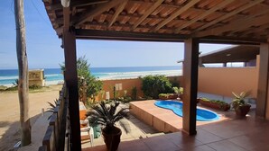 Une terrasse couverte avec vue sur la plage et l’océan.