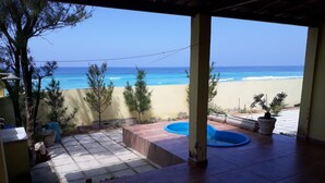 Une terrasse couverte avec vue sur la plage et l’océan.