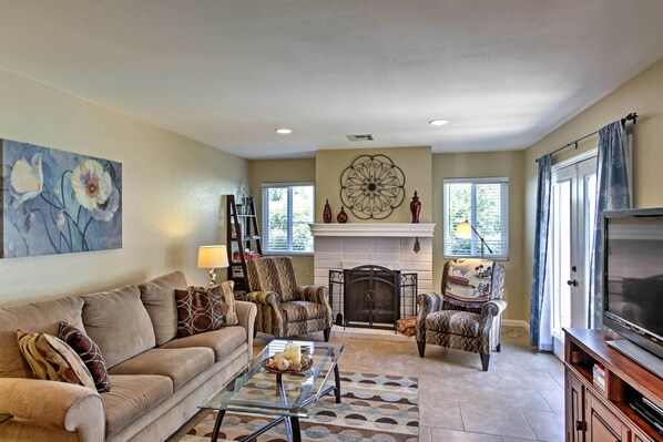 A living room with a fireplace, two armchairs, a sofa, and a television. - Private Home w/ Fire Pit & Patio by Old Town (La Quinta)