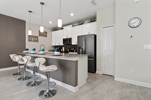 Enjoy cooking in this well-equipped kitchen with a central island, stainless steel appliances, and ample seating for four.