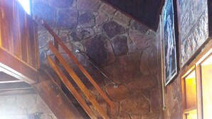 A stone staircase with wooden railings and a small stool at the bottom.