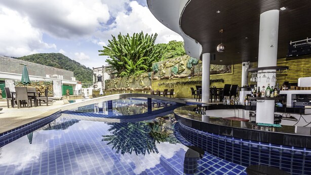 Zona de piscina con vistas despejadas a la arquitectura circundante, que incluye un bar y un área de estar.
