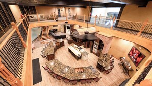 A spacious, multi-level interior with a central island bar, seating areas, and a fireplace. - Zion Red Rock Oasis. (Rockville)