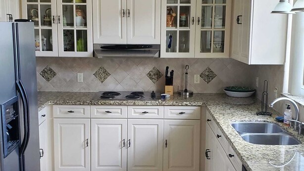 A kitchen with white cabinets, a stainless steel refrigerator, a gas stove, and a double sink. - 4 BR/3 BA Villa, Private Pool - Near Chabad & Anshei (Boynton Beach)