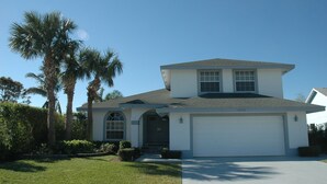 A two-story house with a garage, a front porch, and palm trees. - 4 BR/3 BA Villa, Private Pool - Near Chabad & Anshei (Boynton Beach)