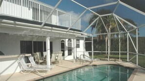 A poolside area with a covered seating area and a pool. - 4 BR/3 BA Villa, Private Pool - Near Chabad & Anshei (Boynton Beach)