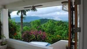 A balcony with a view of lush greenery and mountains.