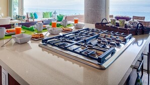 A breakfast setup with a gas stove, dining table, and breakfast items.