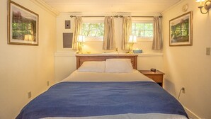 A bedroom with a large bed, two bedside tables, a window with curtains, and wall-mounted lamps. - Abbott Brook Chalet A - Private Setting - 5 Mi  From Storyland (Intervale)