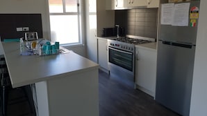 Een moderne keuken met een inbouwoven, een roestvrijstalen koelkast en een raam met uitzicht.