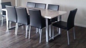 Een eetgedeelte met een rechthoekige tafel en zes stoelen.