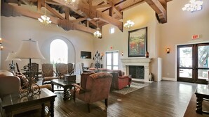 A spacious room with wooden floors, a fireplace, and a large window.
