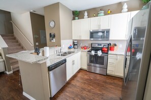 Enjoy cooking in this well-equipped kitchen with a central island, dishwasher, oven, and microwave.