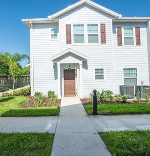Stunning two-story home with a central entrance, flanked by windows and a charming triangular pediment.