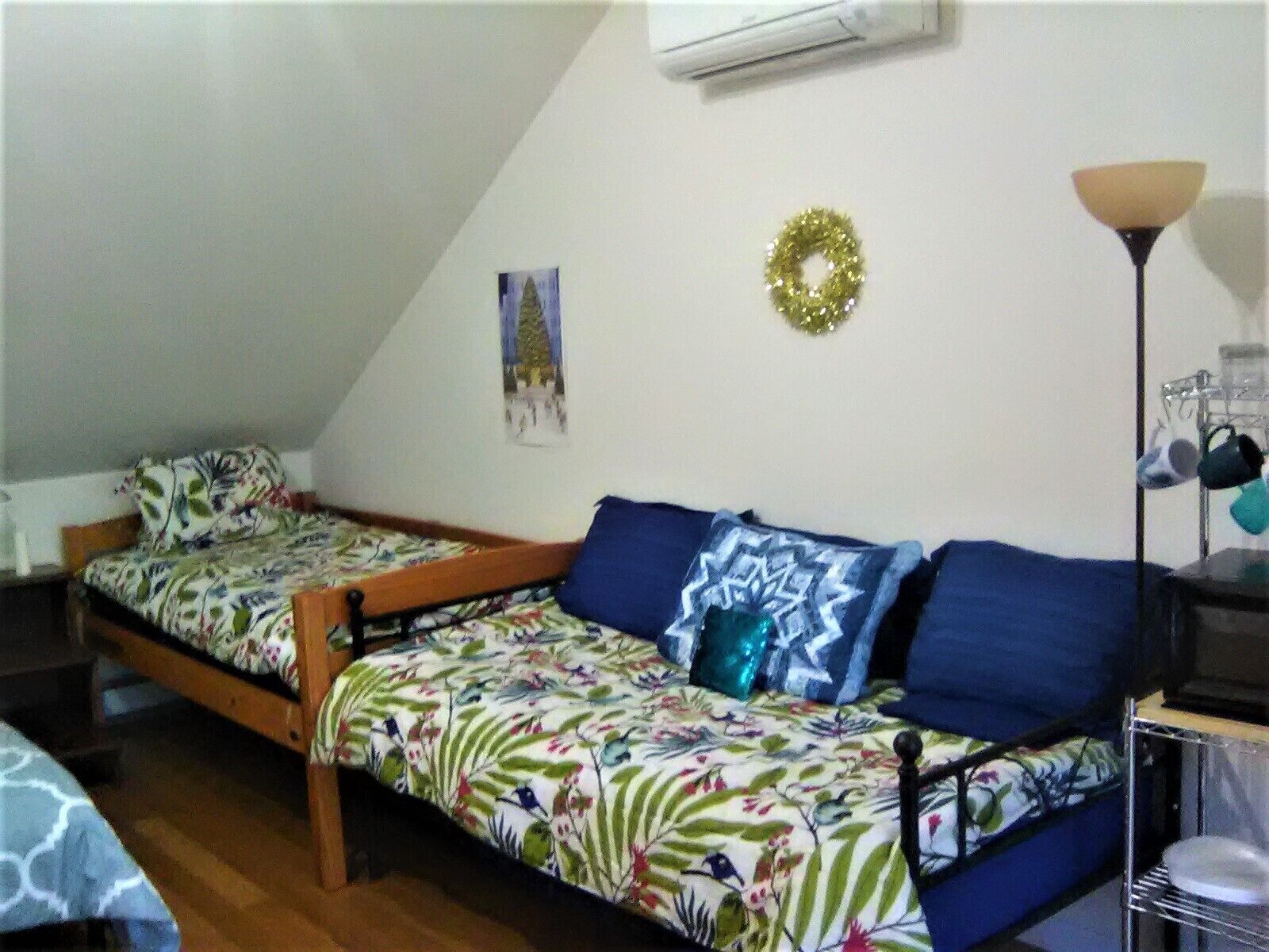 Ein Schlafsaalzimmer mit zwei Etagenbetten, einem kleinen Tisch, einer Lampe und einem an der Wand befestigten Regal mit Hüten.
