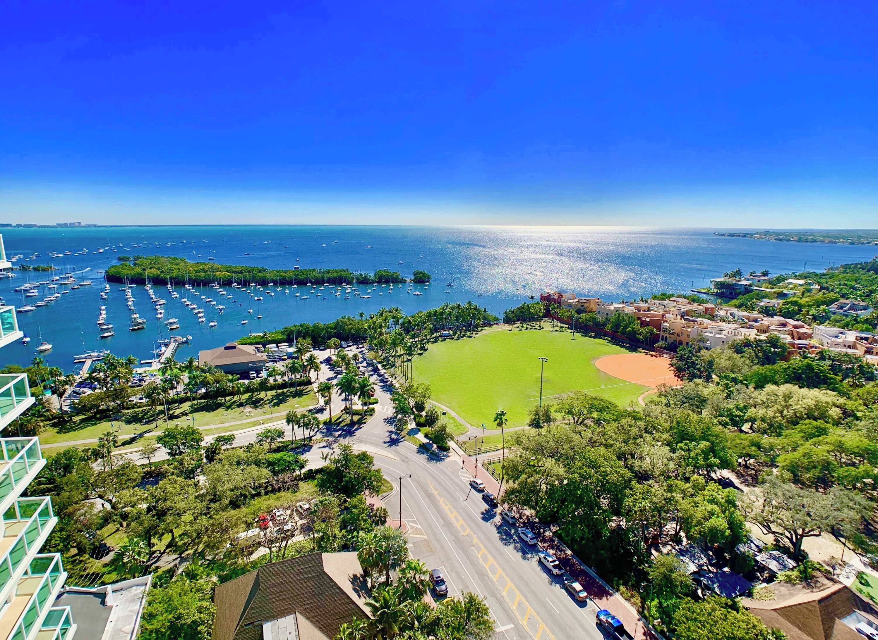 A coastal area with a marina, a baseball field, and residential buildings.