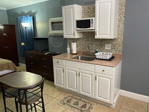 Full-sized fridge, microwave, cookware/dishes/utensils, paper towels