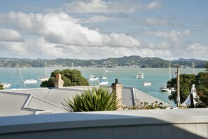 A coastal view with boats on the water, a mountain range in the background, and a building with a roof in the foreground. - Escape North - Extended Family Retreat, located in central Russell (Russell)
