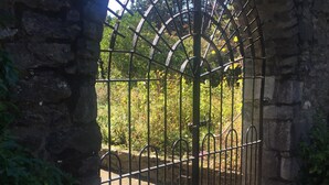 A stone archway leading to a gated area with a metal fence and a paved path. - The Lodge at Bodenlodge is located in the charming Costal Village of Malahide (Malahide)