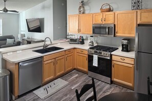 A modern kitchen with wooden cabinets, stainless steel appliances, and a built-in oven. - The Villages 2BR Vacation Home, Lanai & Golf Cart (The Villages)