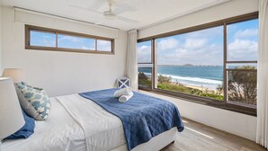 A bedroom with a bed, a nightstand, a lamp, and a view of the ocean. - Parkyn Place 6 - Three Bedroom Oceanview Apartment on Mooloolaba Spit (Mooloolaba)