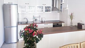 A modern kitchen with white cabinets, stainless steel appliances, and a wooden countertop. - Apartman MAJDA with balkony (Split)